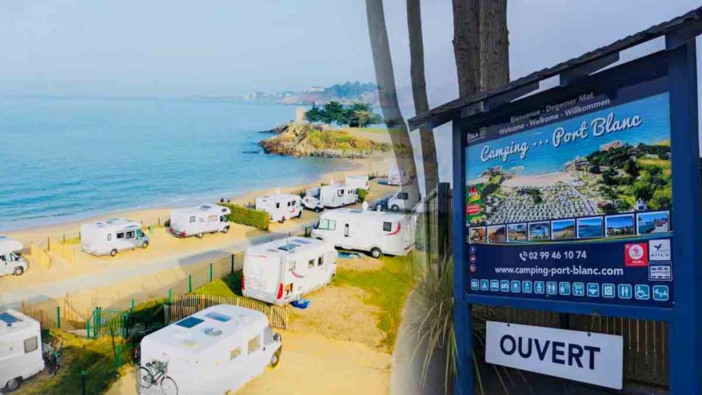 Camping Port Blanc en Bretagne avec caravanes, vue mer et panneau d'ouverture de saison.
