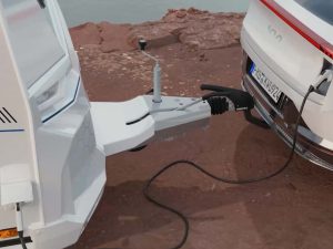 Attelage entre une caravane Knaus YASEO et un véhicule électrique Kia EV6, avec câble de connexion visible pour l’alimentation électrique.