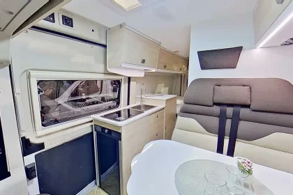 Vue immersive de l’intérieur du van Chausson V594L avec aménagement fonctionnel, espace repas modulable et design chaleureux.