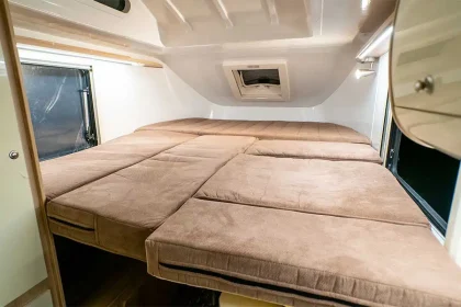 Lit double confortable installé à l’intérieur du camping-car Lada Granta, avec rangements intégrés et éclairage LED