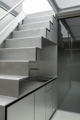 Cuisine compacte de la mini-caravane Esch 22 Space Station avec évier, rangements intégrés et design fonctionnel en inox. Un escalier situé dans la cuisine mène à l’étage supérieur gonflable.