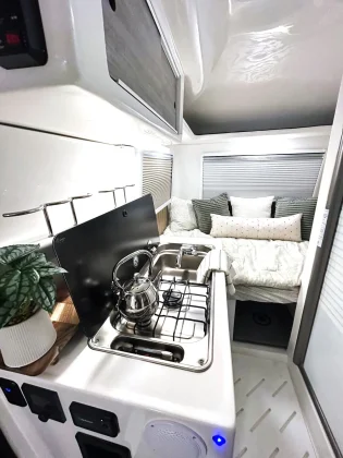 Évier en inox, cuisinière intégrée et coin nuit spacieux pour un confort dans la mini-caravane 
