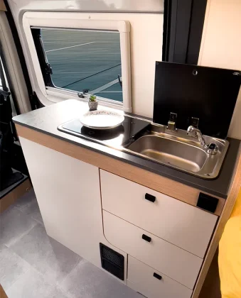 Une cuisine toute équipée, avec plaque gaz 2 feux, frigo à compression et tiroirs de type casseroliers.