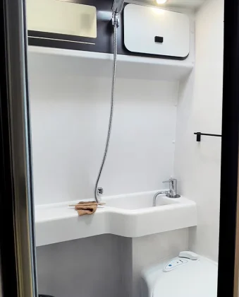 Dans la salle d’eau, vous rangez toutes vos affaires dans un placard en hauteur. Un agencement malin pour vous offrir un espace fonctionnel et pratique.