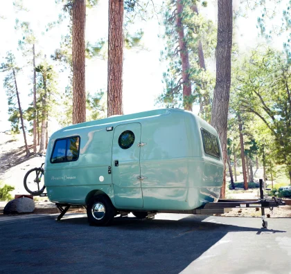 Vue extérieure de la mini-caravane Happier Camper HC1 Breeze, au design rétro et compact, idéale pour les escapades nomades grâce à son aménagement modulable et léger