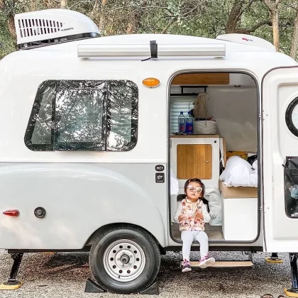 Aménagement intérieur de la mini-caravane Happier Camper HC1 avec modules adaptatifs, banquettes confortables, rangements intégrés et style rétro moderne