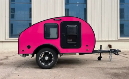Mini-caravane Virgule CC teardrop de couleur rose vif vue de profil, design compact et moderne, parfaite pour les road trips en duo.